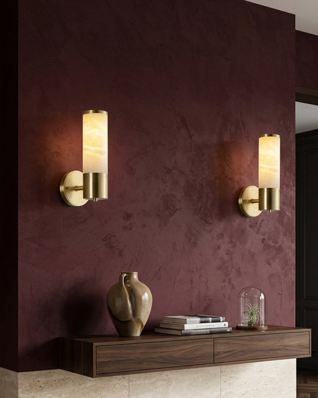 Applique murale en marbre et laiton sur un mur bordeaux au-dessus d'une console