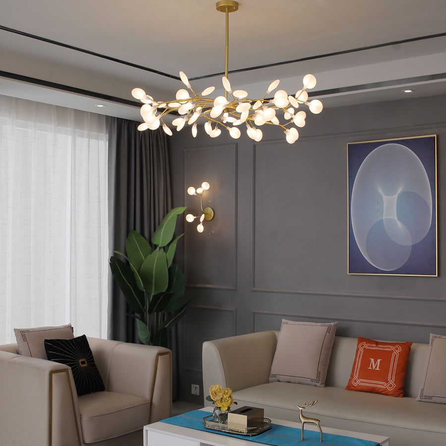 Lustre branche doré allumé dans un séjour aux boiseries et rideaux verts Image