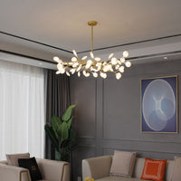 Lustre branche doré suspendu dans un salon aux murs gris et fauteuils beiges