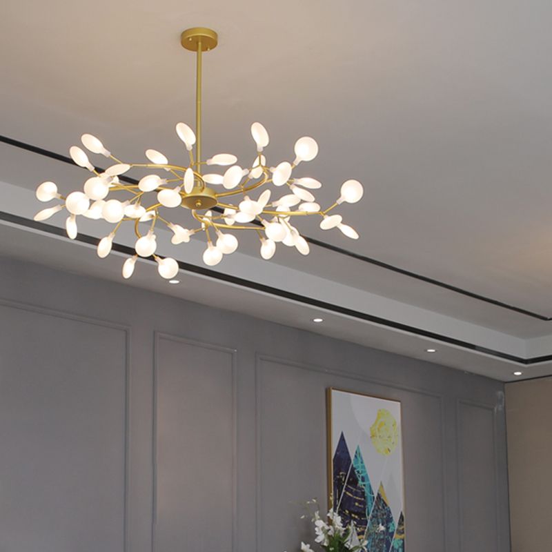 Lustre branche doré éclairé au-dessus d'un salon contemporain