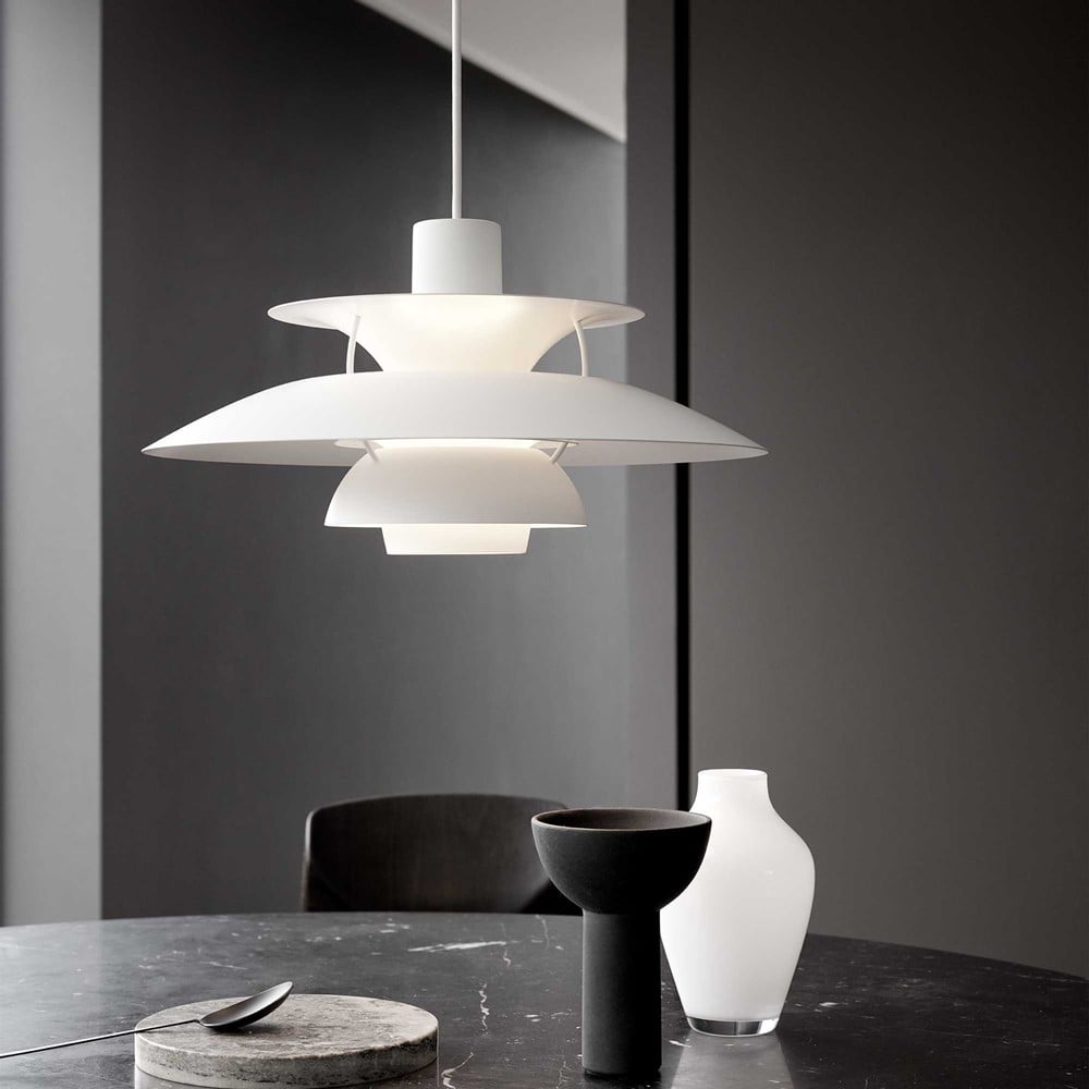 Suspension scandinave en métal coloré blanche au-dessus d'une table en marbre sombre
