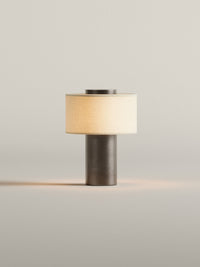 Lampe de table sans fil finition bronze profond allumée sur fond clair