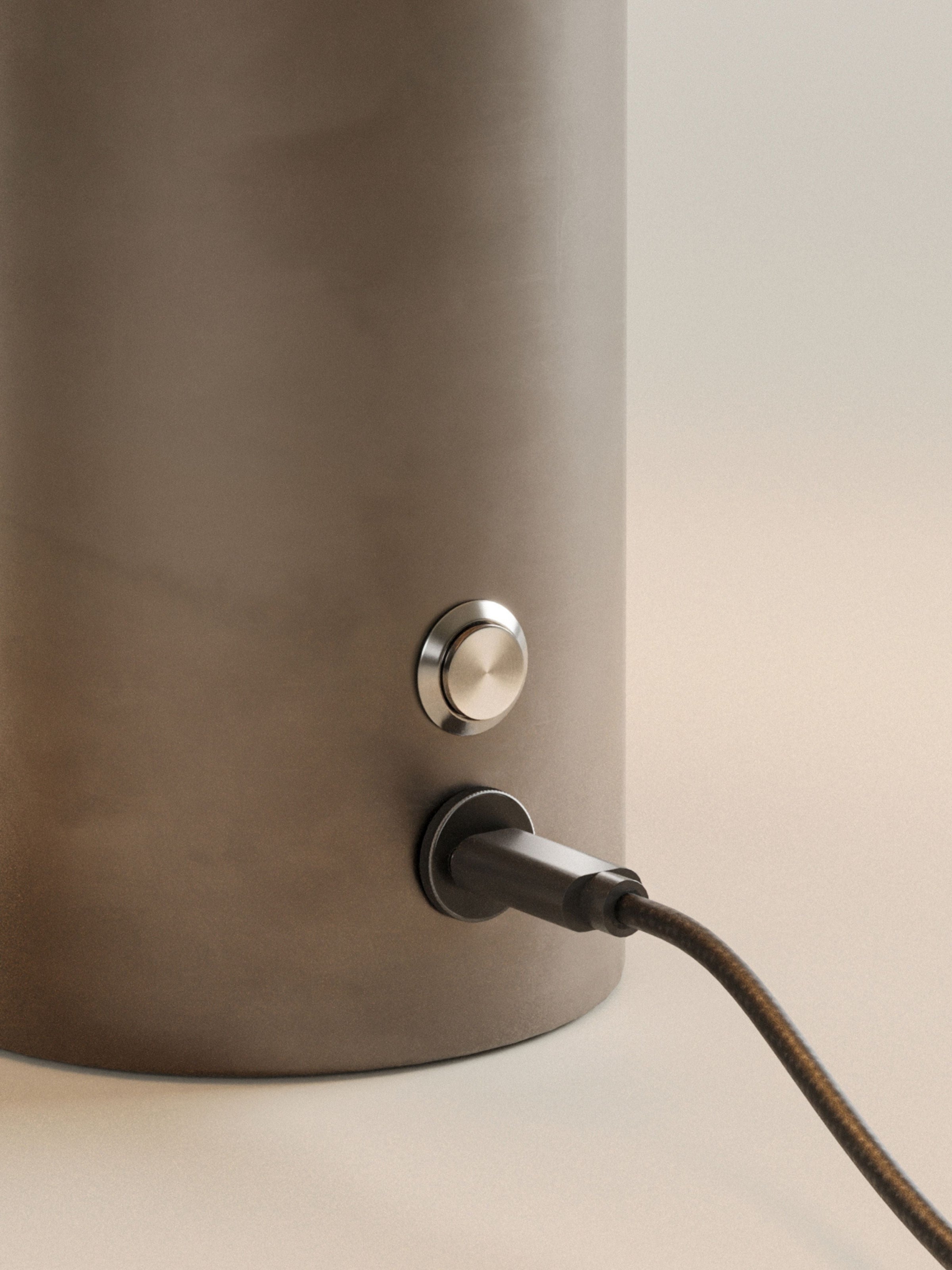 Gros plan sur le port USB-C du socle finition bronze avec son câble