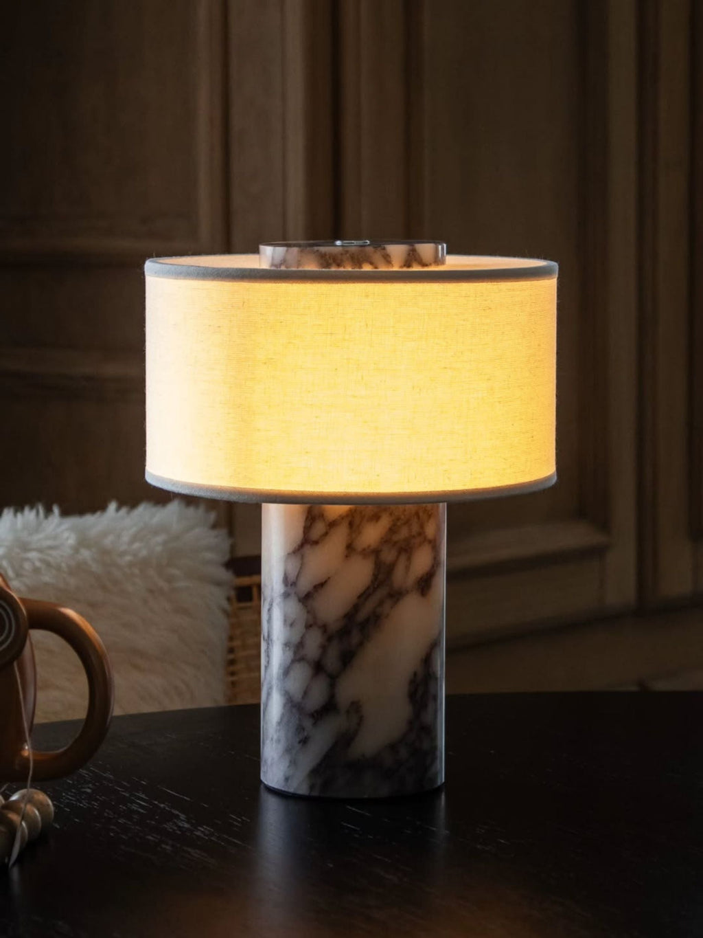 Lampe de table sans fil allumée dans une pièce sombre et boisée