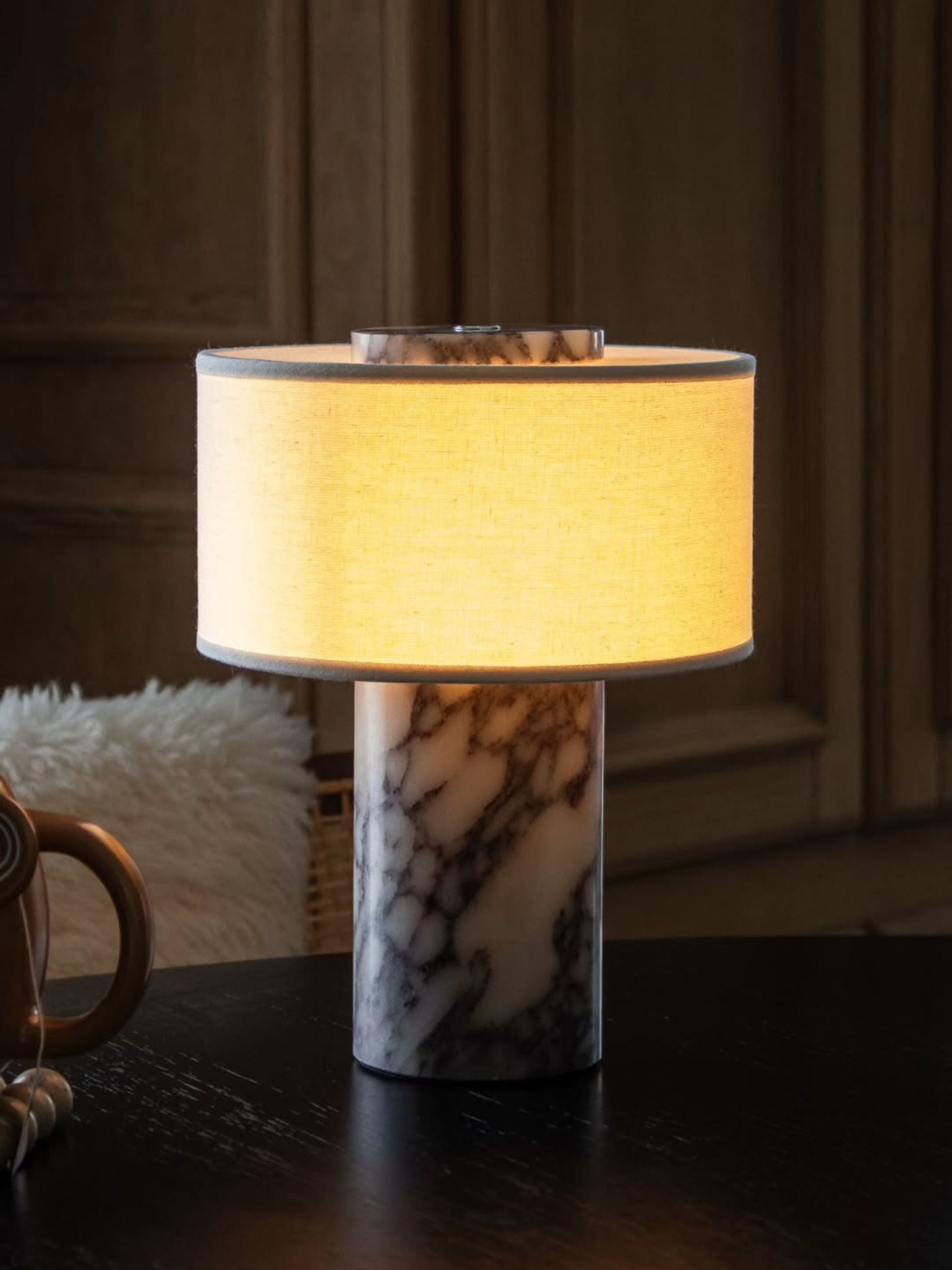 Lampe de table sans fil allumée dans une pièce sombre et boisée Image