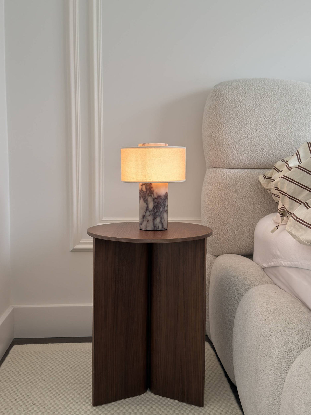 Lampe de table sans fil allumée près d'un fauteuil en tissu bouclé