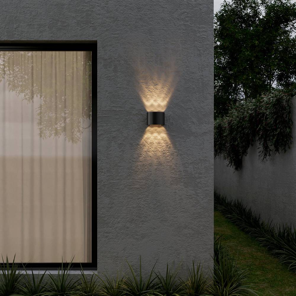 Applique murale LED étanche noire sur un mur extérieur en crépi
