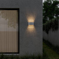 Applique murale LED étanche blanche sur une façade extérieure de nuit