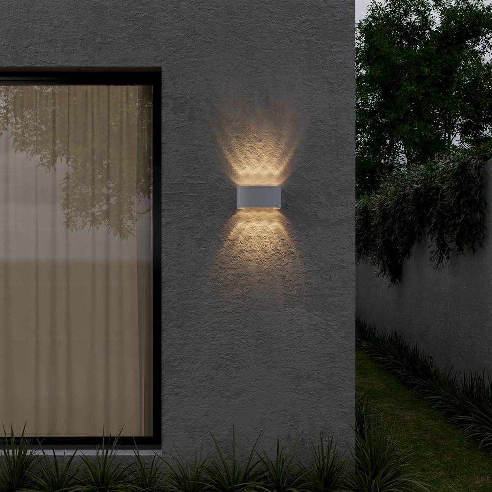 Applique murale LED étanche blanche sur une façade extérieure de nuit Image