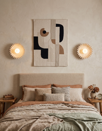 Applique murale design en céramique installée en paire au dessus d'une tête de lit