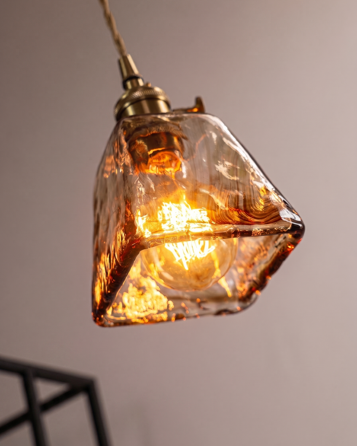 Suspension verre ambré allumée diffusant une lumière chaude dans un intérieur
