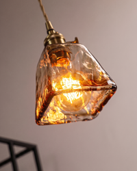 Suspension verre ambré allumée diffusant une lumière chaude dans un intérieur