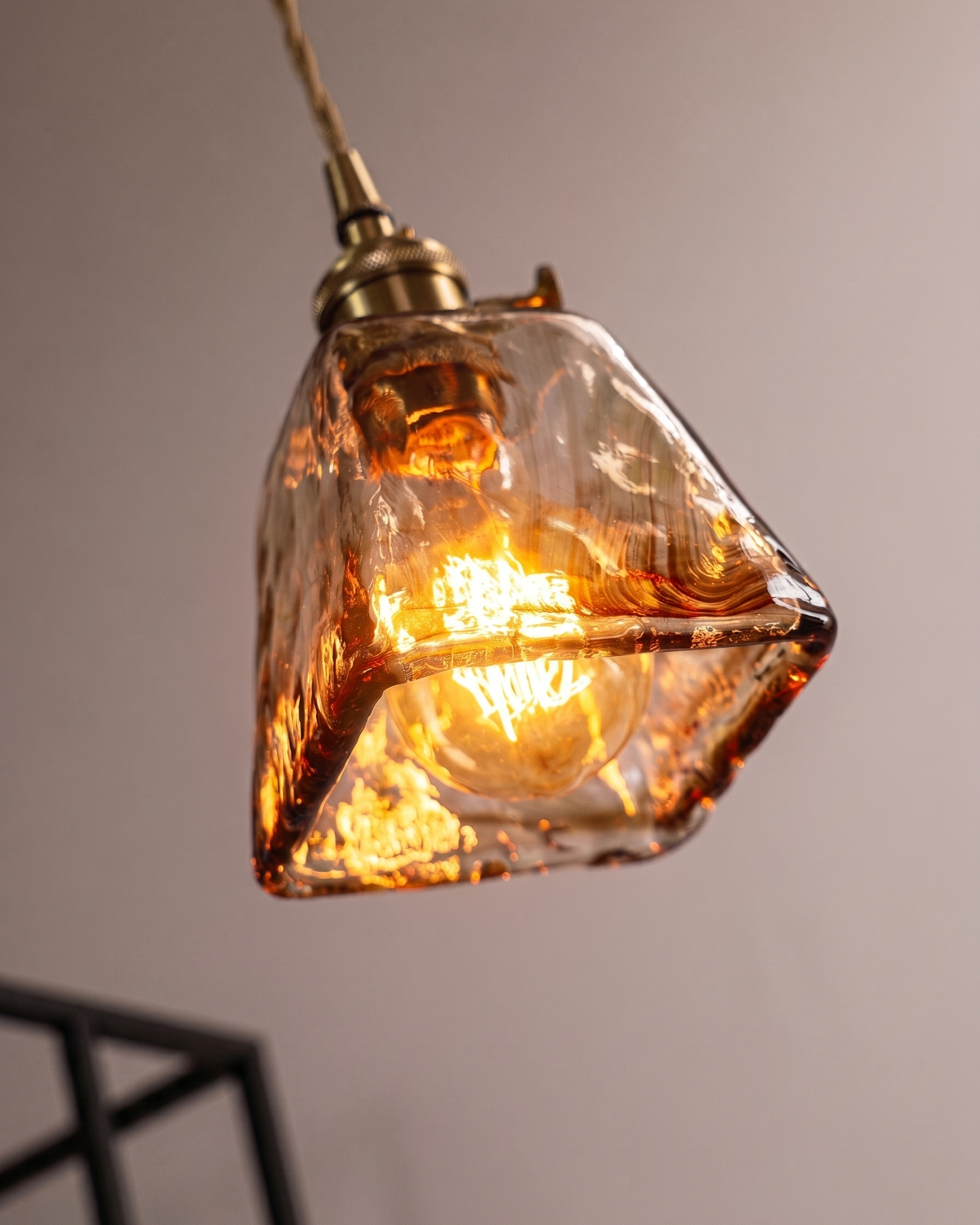 Suspension verre ambré allumée diffusant une lumière chaude dans un intérieur