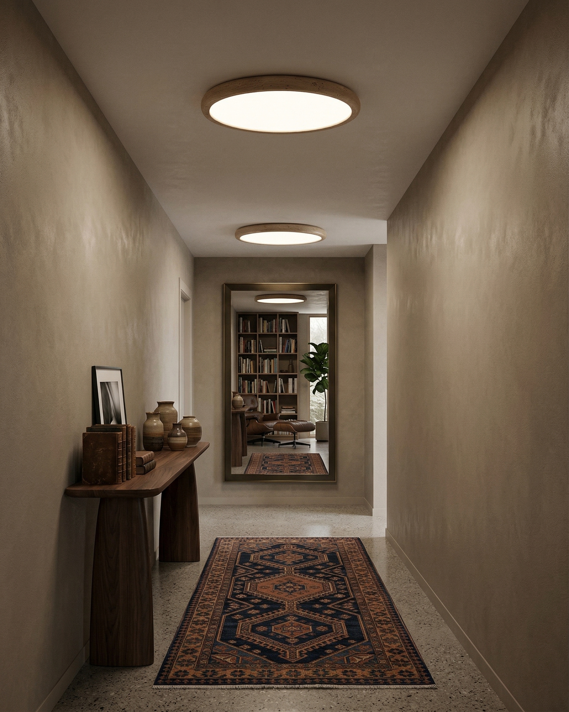 Deux plafonniers design en travertin éclairant un couloir aux murs taupe