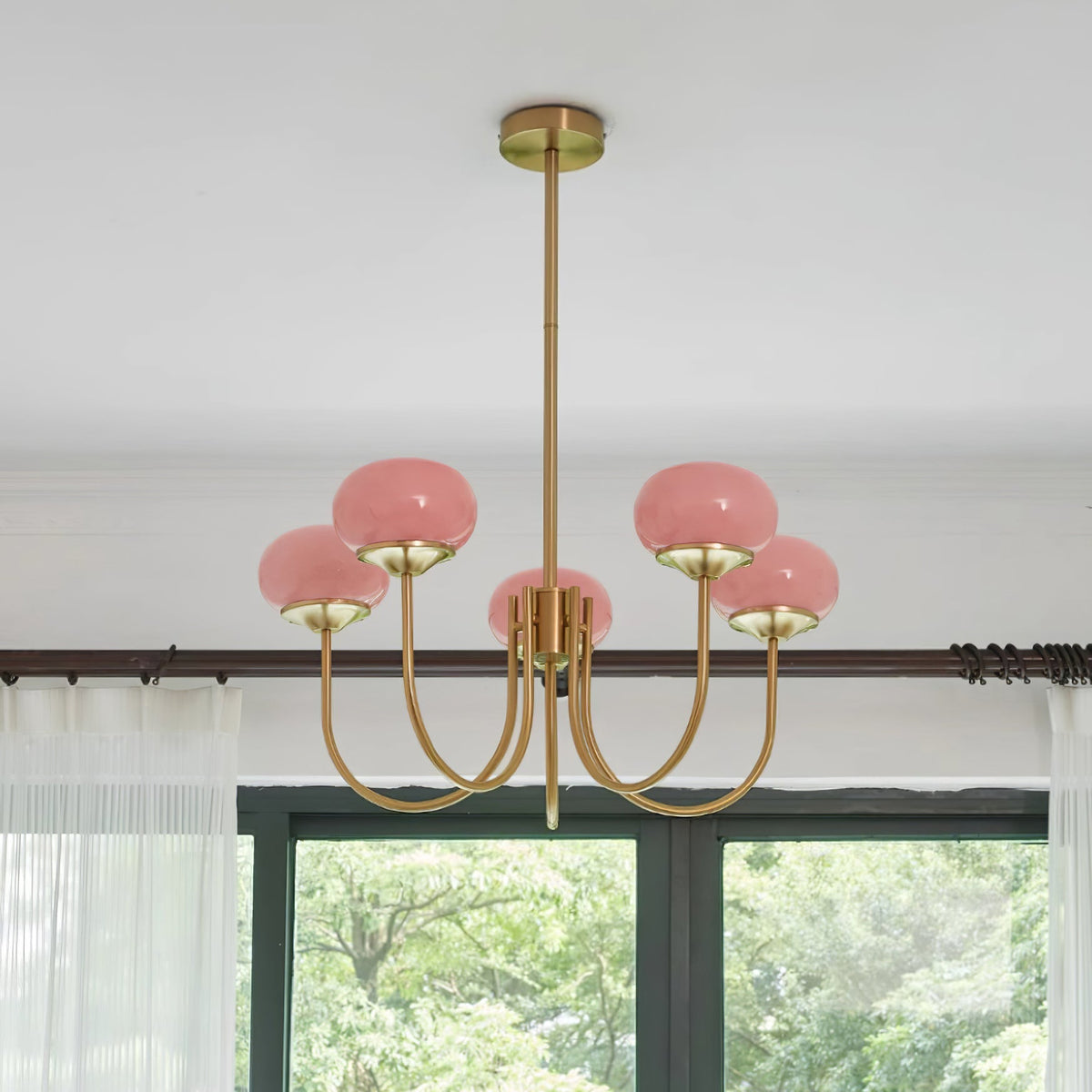 Lustre en verre rose cinq lumières devant une baie vitrée