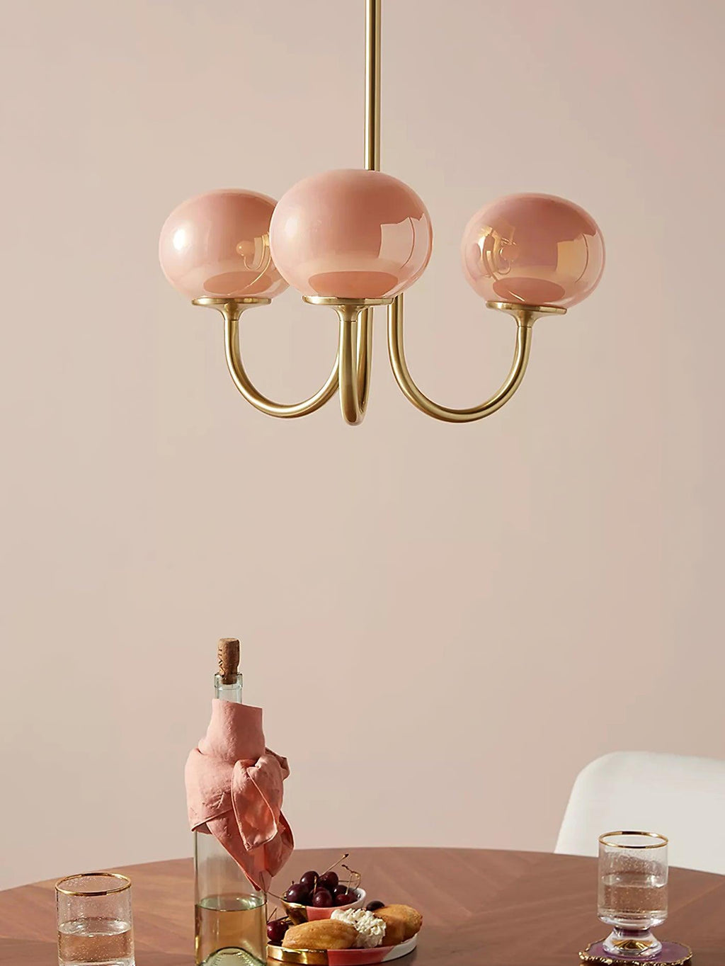 Lustre en verre rose dans une salle à manger avec chaises colorées