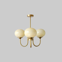Lustre trois lumières finition cuivre et abat-jours crème