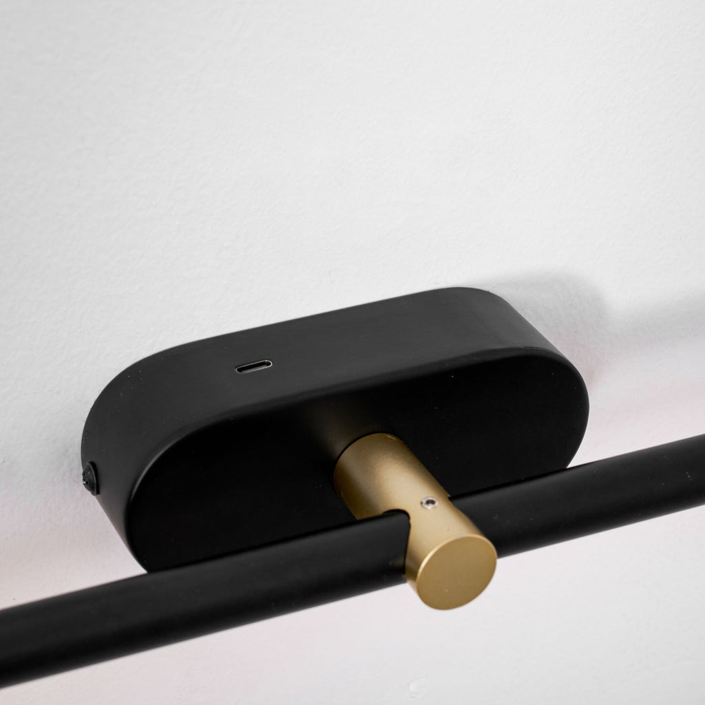 Détail de la platine noire et du bouton tactile en laiton