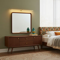 Applique sans fil dorée au-dessus d'un miroir dans une chambre