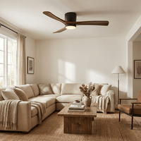 Ventilateur de plafond en bois allumé au-dessus d'un grand canapé en lin