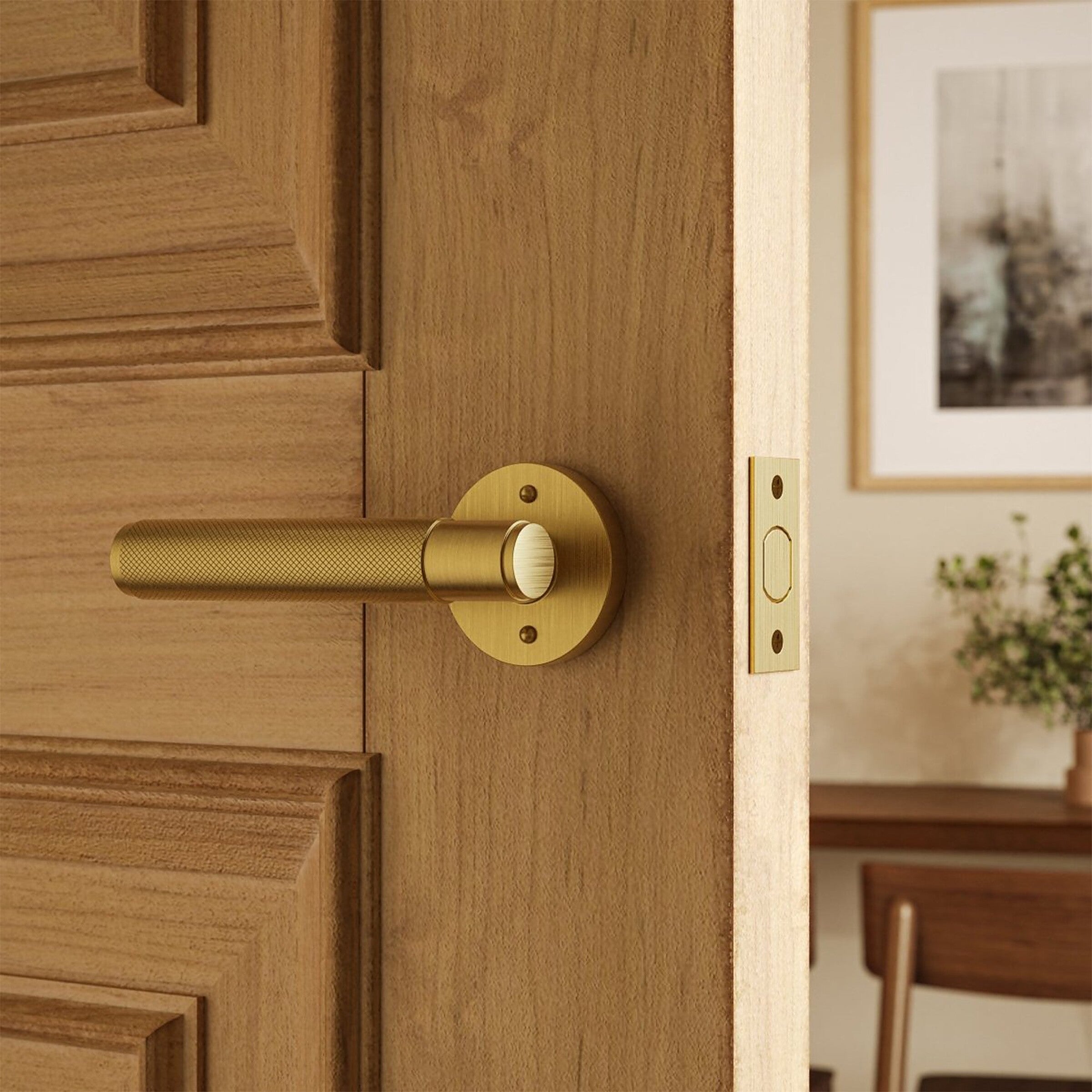 Poignée de porte laiton brossé sur porte en bois clair