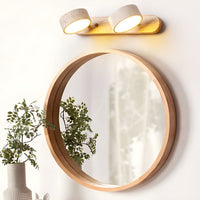 Applique en travertin allumée au-dessus d'un miroir rond en bois