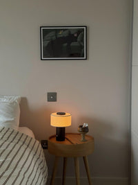 Lampe de table sans fil finition bronze sur une table de chevet