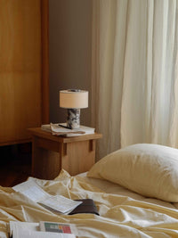 Lampe de table sans fil allumée sur une table de chevet en bois