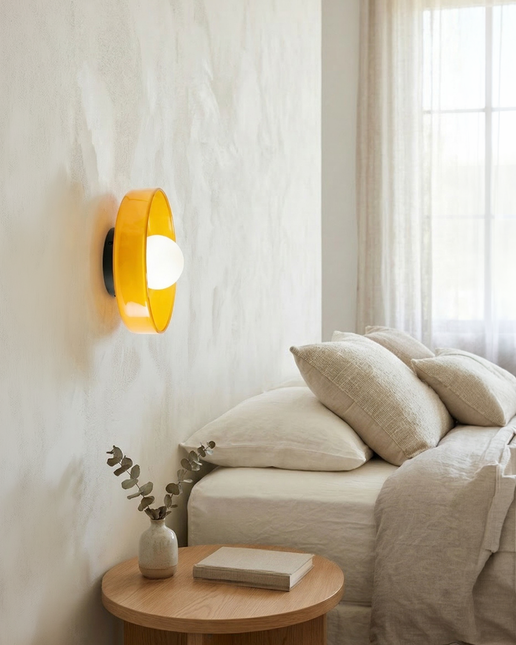 Applique murale en verre orange au-dessus d'une table de chevet
