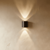Applique murale LED étanche noire 2W sur mur texturé beige