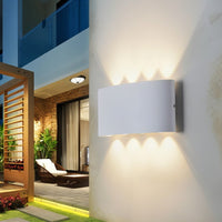 Applique murale LED blanche à huit faisceaux sur une terrasse le soir