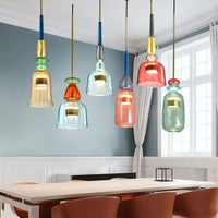 Suspensions verre vitrail multicolores au-dessus d'une table dans une salle au mur bleu