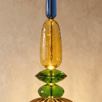 Détail du verre soufflé ambre et vert de la suspension vitrail
