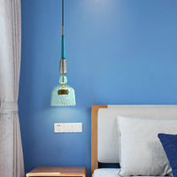 Suspension verre vitrail bleue au-dessus d'un chevet dans une chambre au mur bleu