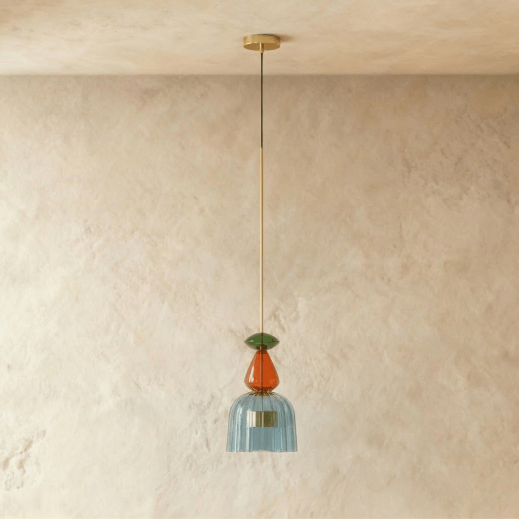 Suspension verre bleu vitrail allumée, lumière douce sur mur clair
