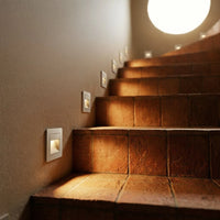Éclairage escalier en terre cuite avec spots encastrés diffusant une lumière chaude