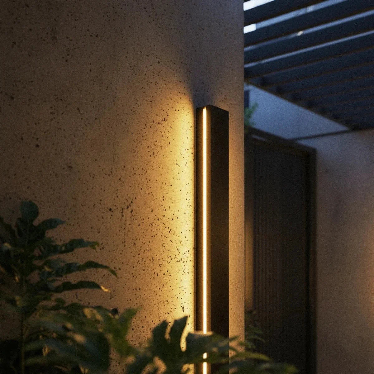 Applique murale extérieure LED sur un pilier en béton entouré de végétation