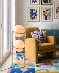 Lampadaire à deux globes près d'un fauteuil jaune