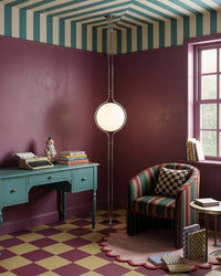 Lampadaire boule tension sol plafond dans un salon violet