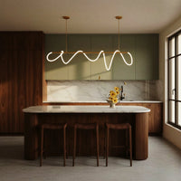 Suspension LED design dorée au-dessus d'un îlot de cuisine en marbre blanc