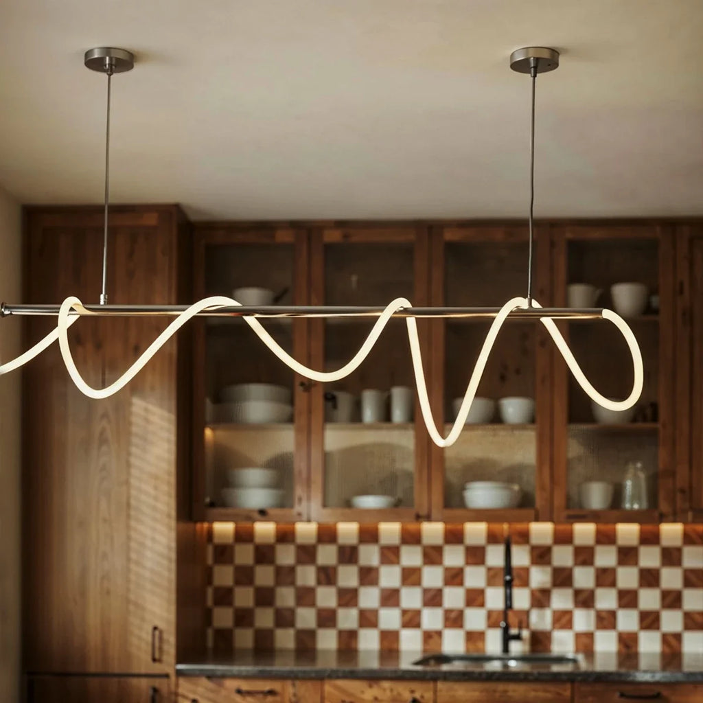 Détail du tube LED ondulé allumé devant un vaisselier en bois