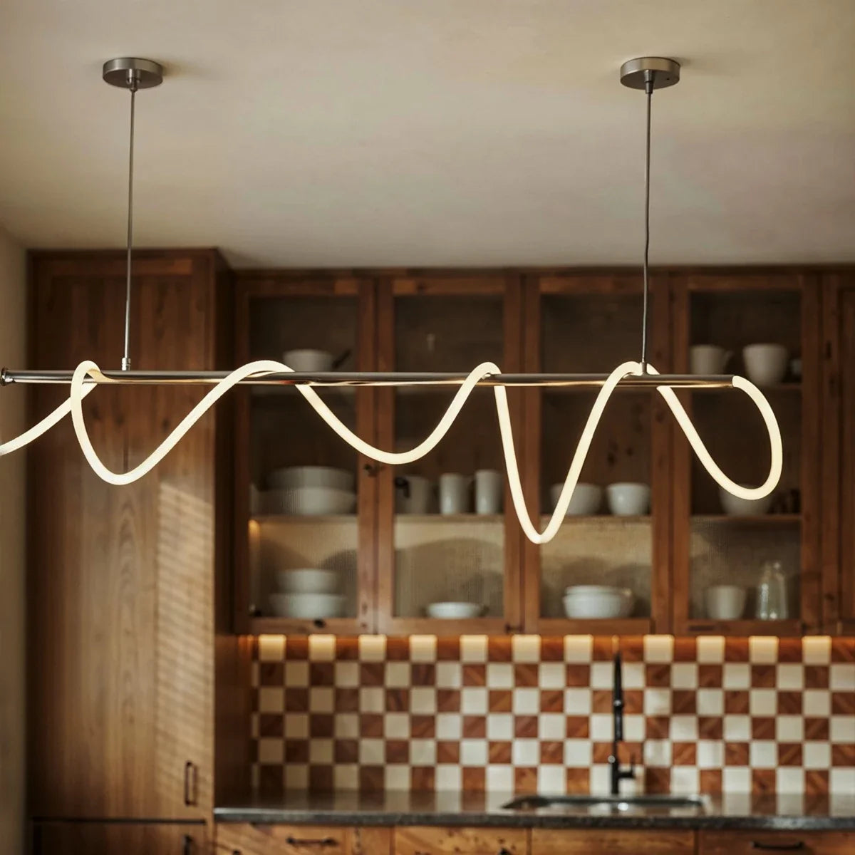 Détail du tube LED ondulé allumé devant un vaisselier en bois
