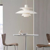 Suspension scandinave en métal coloré blanche au-dessus d'une petite table de repas