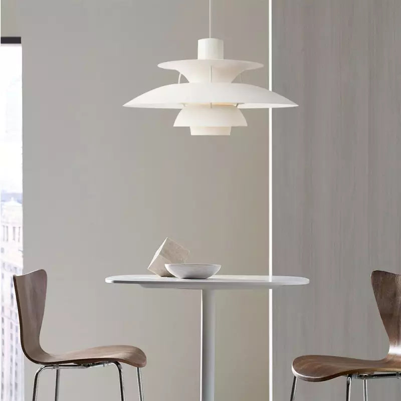 Suspension scandinave en métal coloré blanche au-dessus d'une petite table de repas