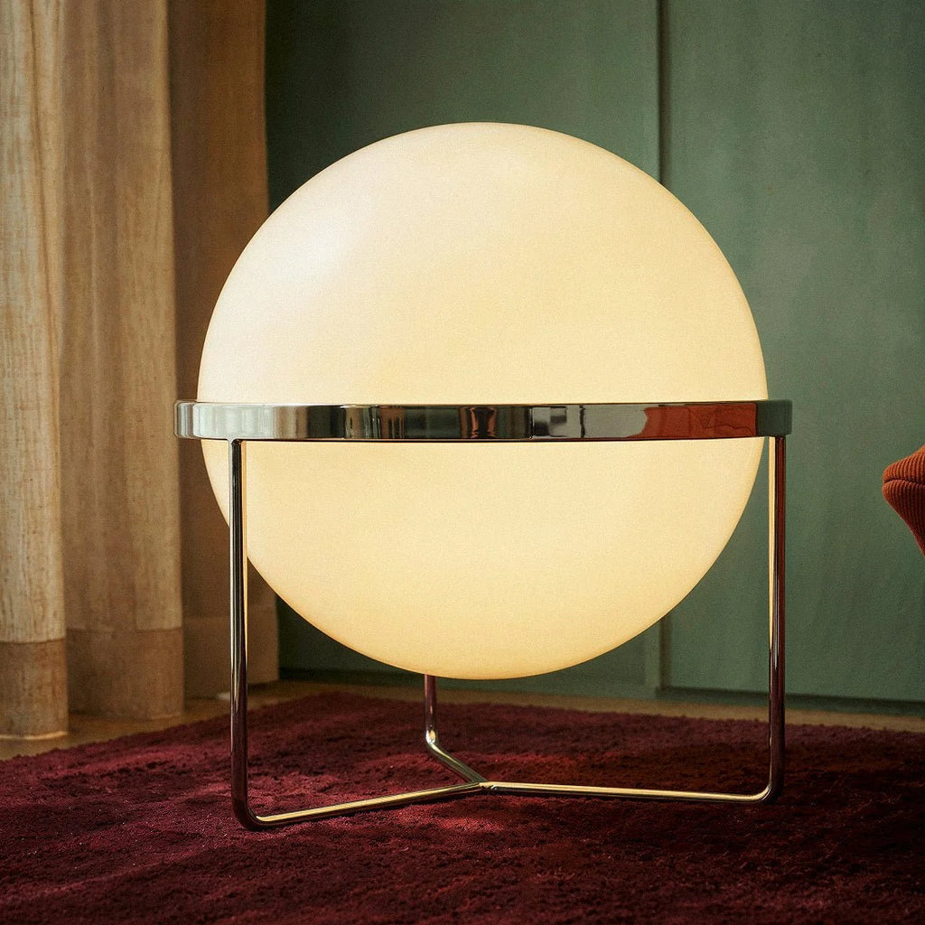 Gros plan sur la sphère lumineuse du lampadaire design et son anneau chromé