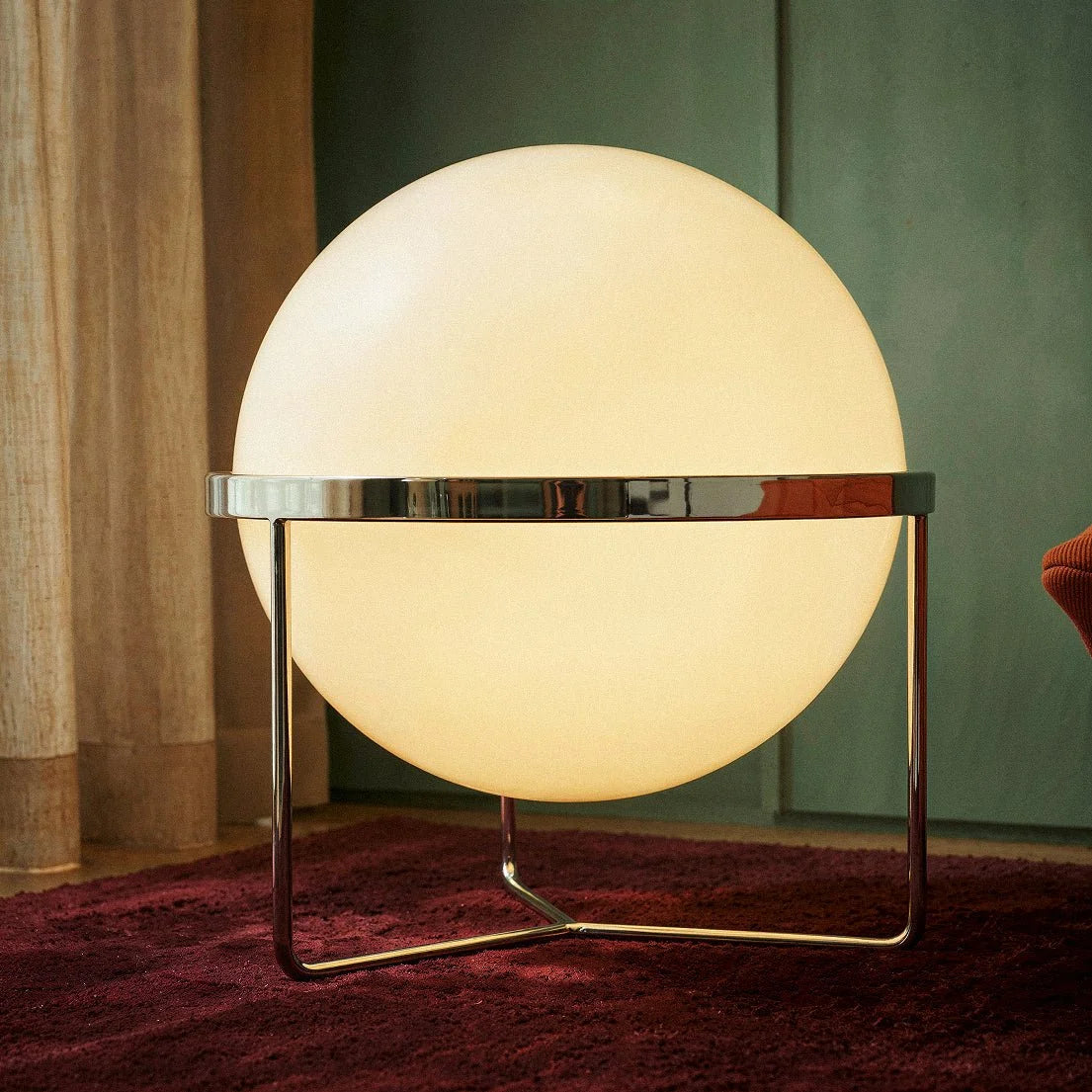 Gros plan sur la sphère lumineuse du lampadaire design et son anneau chromé