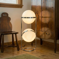 Lampadaire design à deux étages chromé dans un intérieur en bois