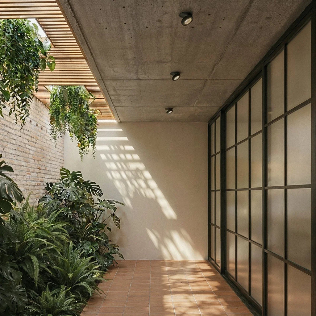 Spots encastrables orientables noirs alignés au plafond béton d'une galerie
