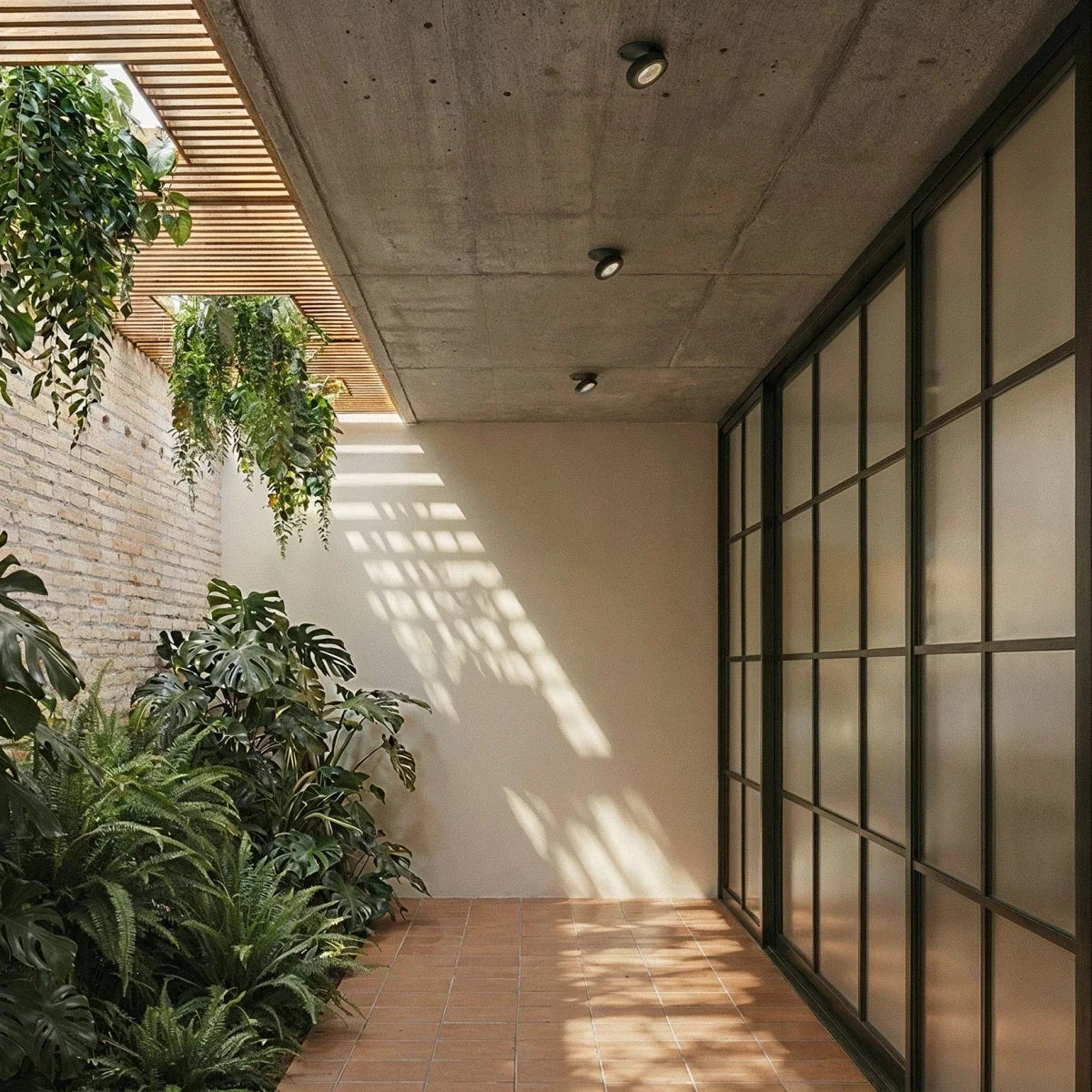 Spots encastrables orientables noirs alignés au plafond béton d'une galerie