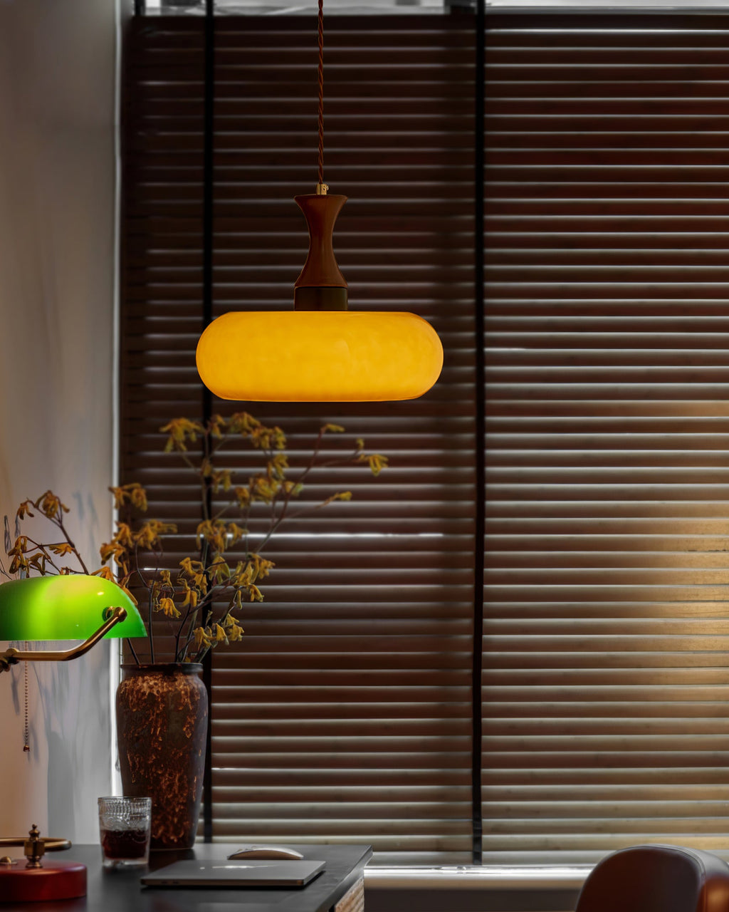 Suspension baladeuse en verre allumée dans une ambiance tamisée du soir
